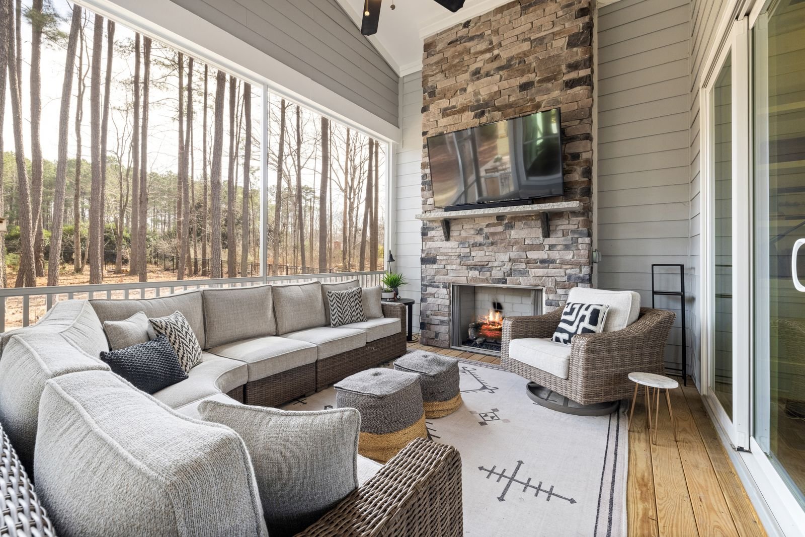 Covered patio with a stone outdoor fireplace and lounge seating